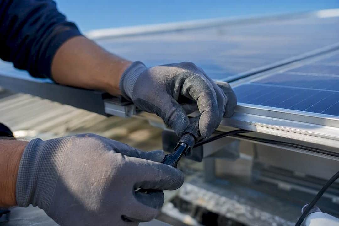 Ein Elektrotechniker installiert eine Photovoltaikanlage.