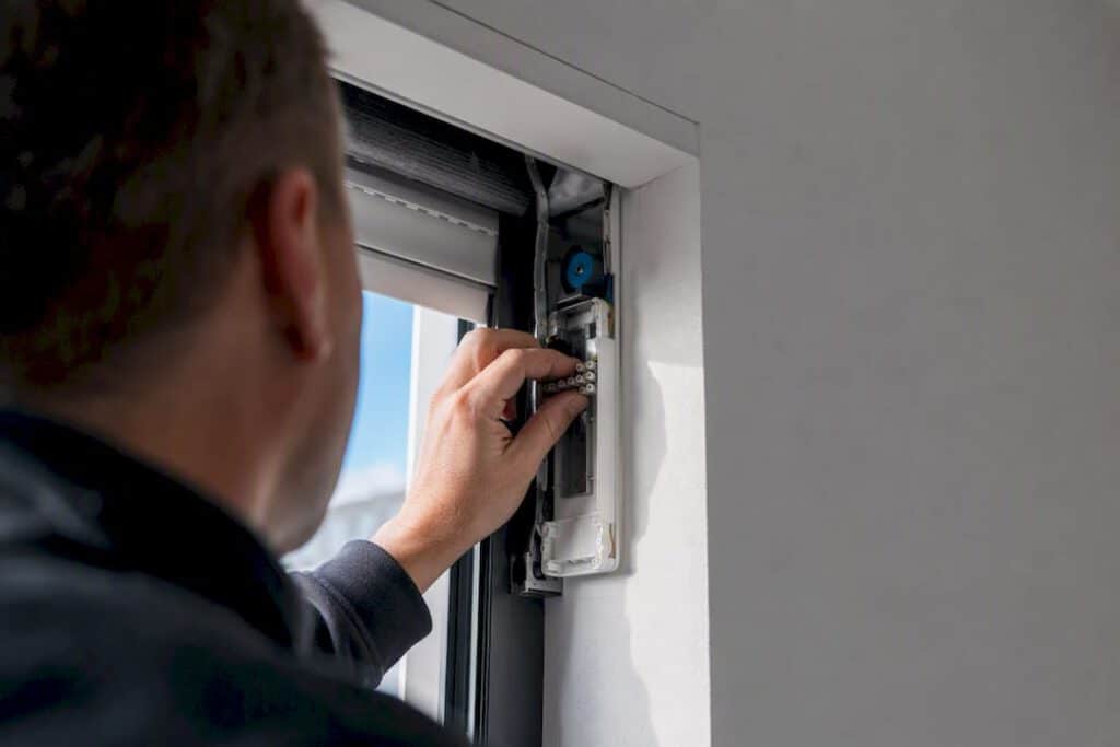 Ein Elektriker überprüft den Anschluss eines elektrischen Rollladens