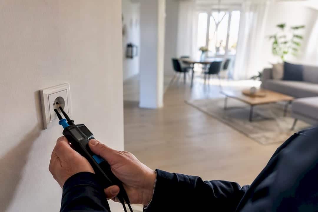 Elektriker nimmt Steckdose vor Auftragserteilung unter die Lupe